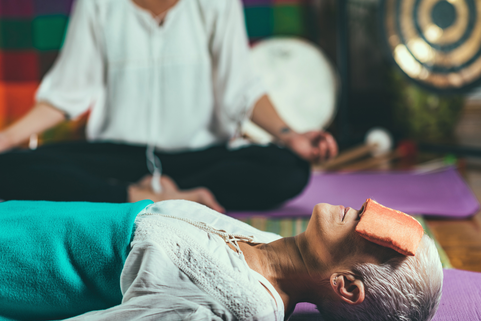 Senior woman lying down in a guided meditation class